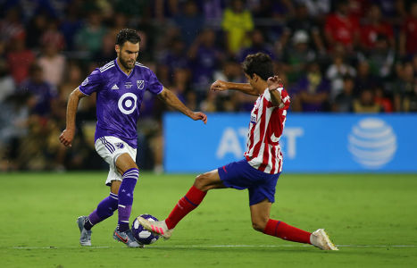 Graham Zusi tries to evade an Athletico Madrid player — soccer — MLS, soccer, allstar